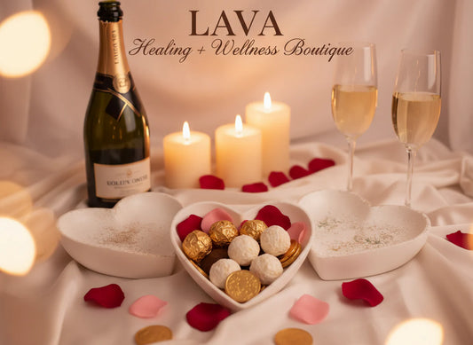 Bottle of champagne, candles, and heart-shaped holder with chocolates 