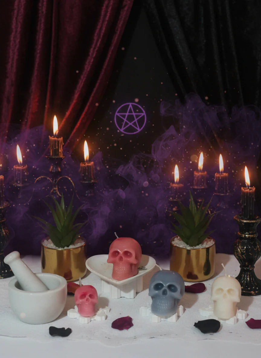 Villain setup with candles, skull figurines, and plants on a dark background.